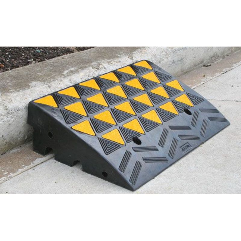 krr150 Hi-Viz Kerb Ramp Body Rubber 600mm x 360mm x 150mm - Black/Yellow 3 Black curb ramp with yellow triangles, designed for accessibility, positioned against a concrete curb.