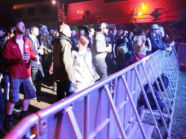 Crowded event: People behind barrier at a music event. Crowd control is important for organising a crowded event. Concert with a large crowd.