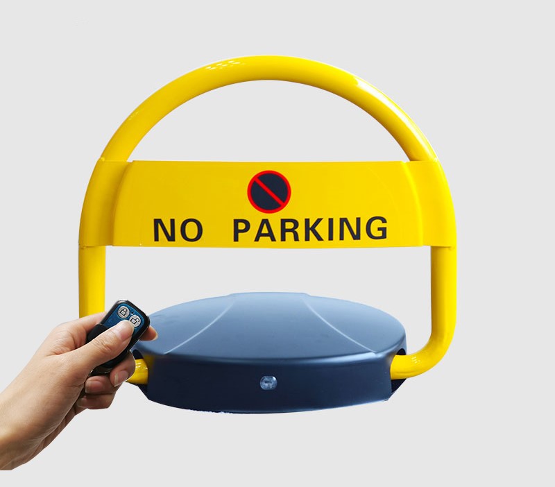 Dugite automatic parking bollard. Yellow parking barrier with No Parking sign. Hand holds remote control for automatic parking bollard.