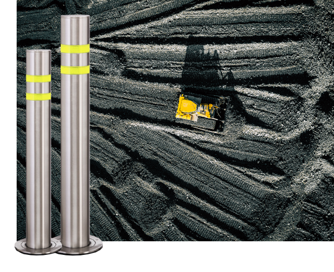 Stainless steel bollards with yellow bands, bulldozer on dark ground. Home page image showing site safety and construction equipment.