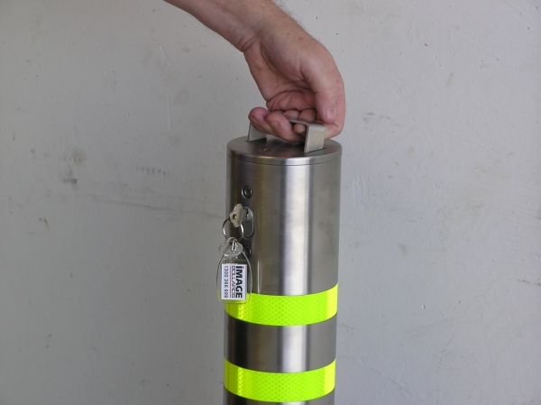 Removable bollards Perth Is it Easy to Install Removable Bollards? 1 Hand lifts removable bollard. Stainless steel post has reflective yellow bands. Key is visible. Easy to install bollards provide security.