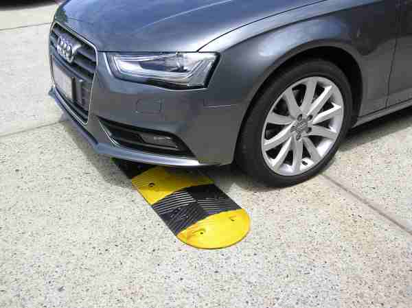 Rubber Speed Humps reduced 4 Advantages of Rubber Speed Humps 1 Gray car driving over a yellow and black rubber speed hump. Advantages of rubber speed humps include visibility and durability.