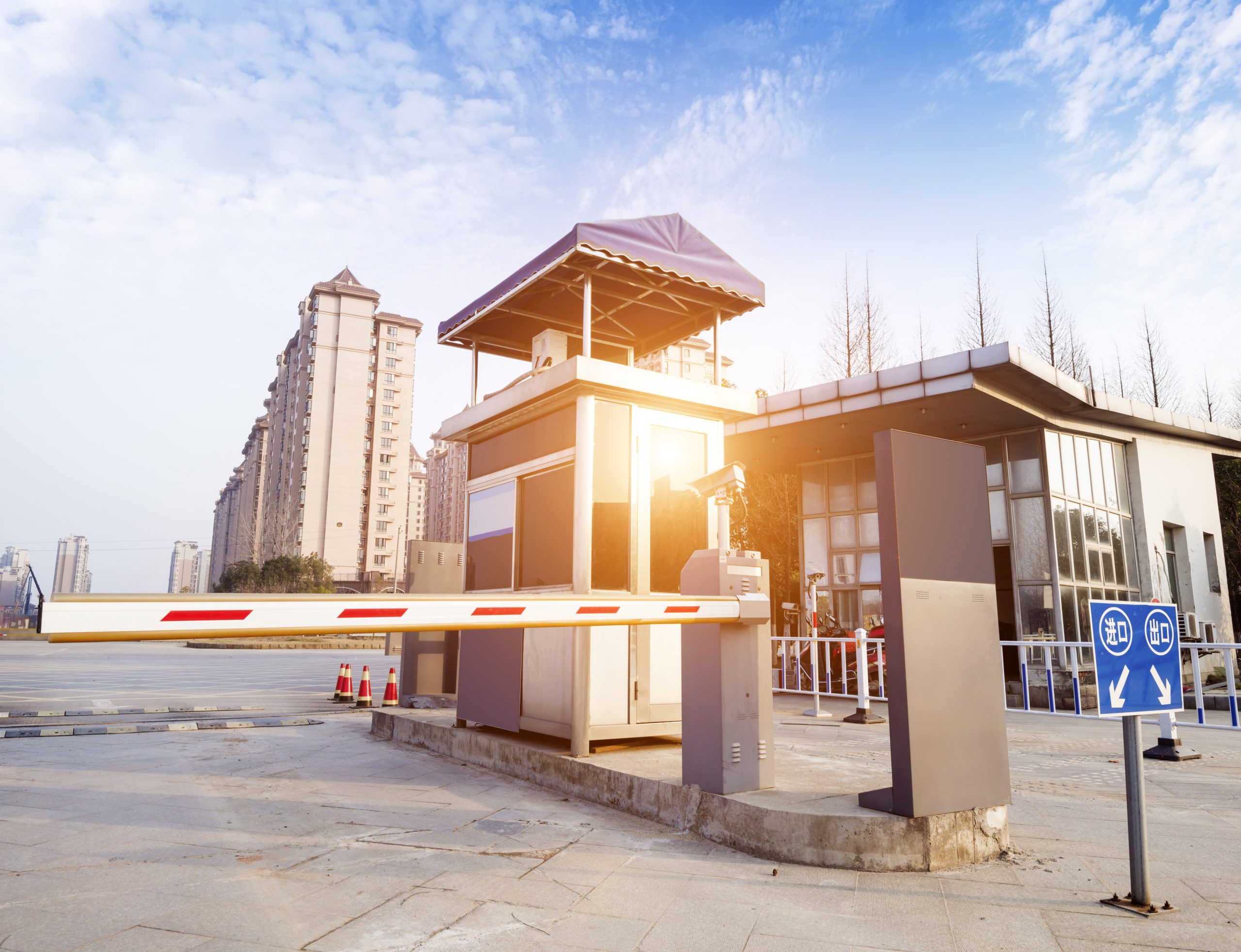 Secure Your Place with Safety Barriers scaled 1 Secure Your Place with Safety Barriers 1 Safety barrier with a security booth and a boom gate in front of buildings, ensuring controlled access and enhanced safety measures.