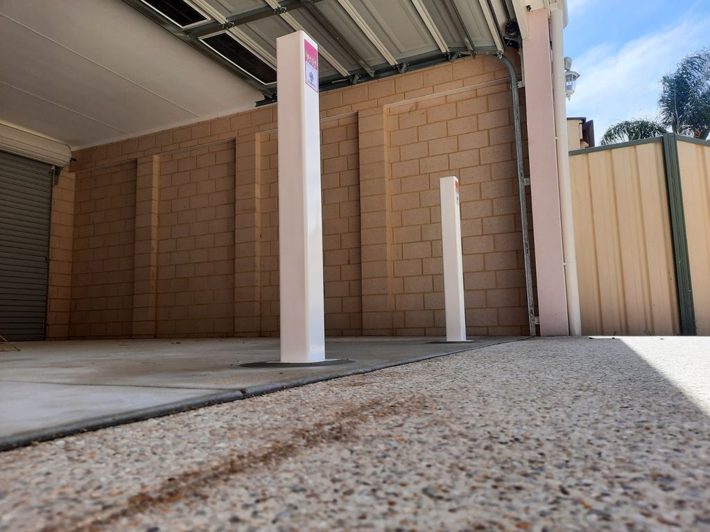 image 1708053057194768 Dugite Bronze 90mm x 900mm Retractable Bollard 3 Dugite Bronze retractable bollard, 90mm x 900mm, installed in front of a garage. White bollards offer security and access control.
