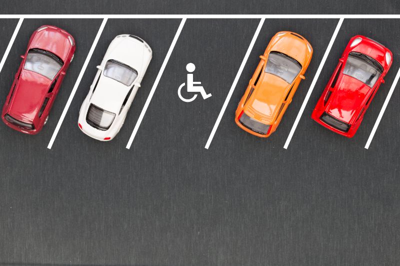 Overhead shot of a parking lot with toy cars, including a handicap accessible parking space. Accessibility checklist for events.
