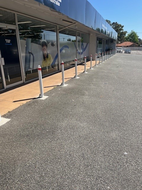 Row of removable bollards in Perth outside a building. These bollards enhance safety and flexibility for traffic and pedestrian management.